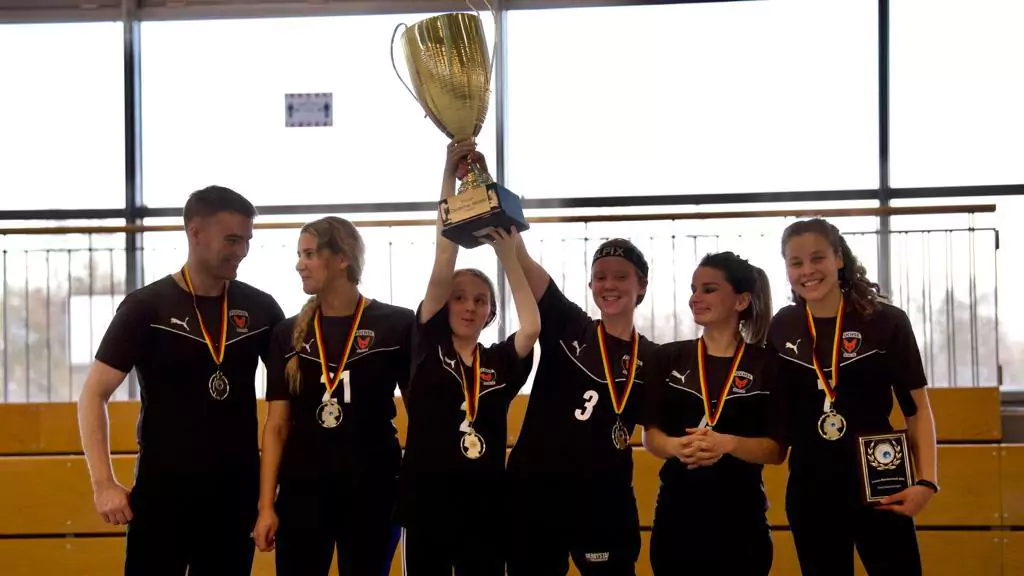 Die Frauen Goalball Mannschaft hält den Pokal hoch. Alle freuen sich